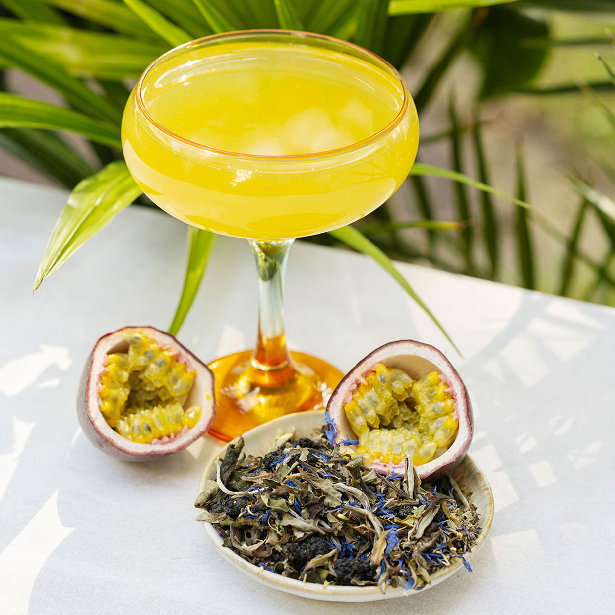 Sparkling Harmony im Glas mit Kräutern und Passionsfrucht